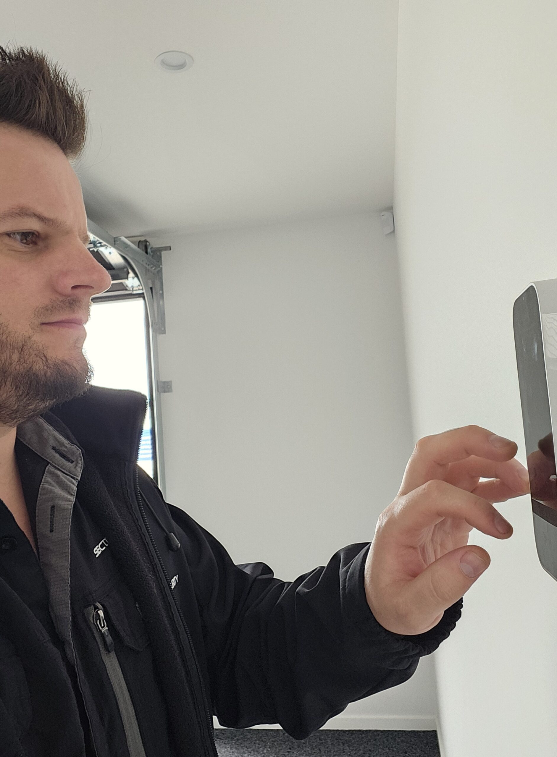 Sectek technician testing a wall-mounted security keypad